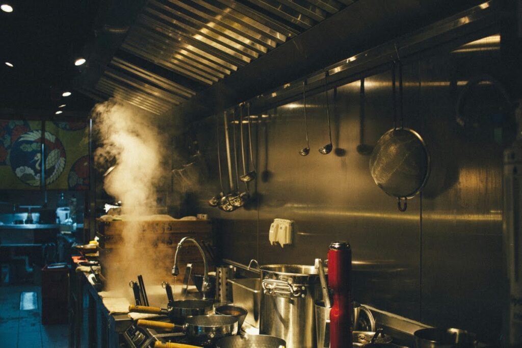 Chef taking notes and preparing for a commercial kitchen hood inspection.