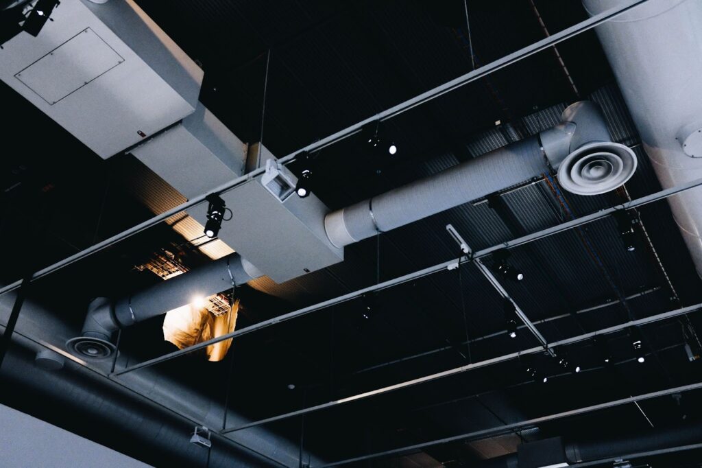 Ceiling with ventilation pipes showing airflow in a commercial kitchen.