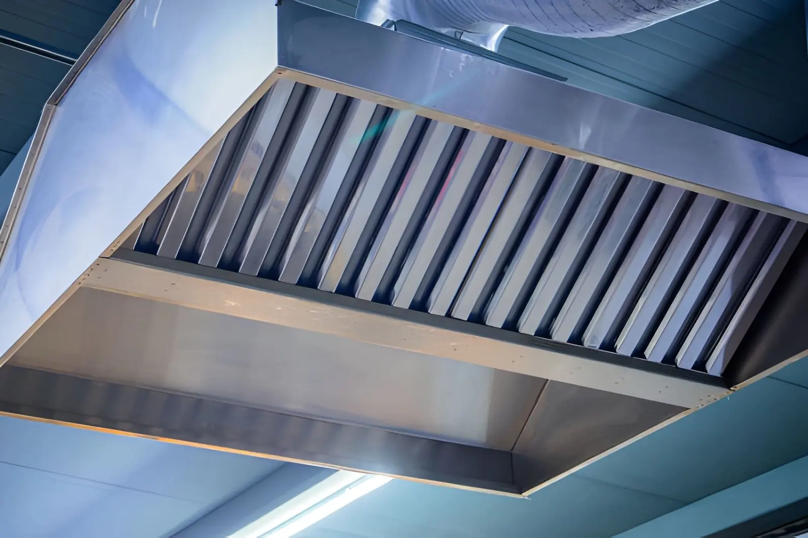 Commercial technician inspecting ventilation system for Kitchen Exhaust Fan Repair Near Me service efficiency
